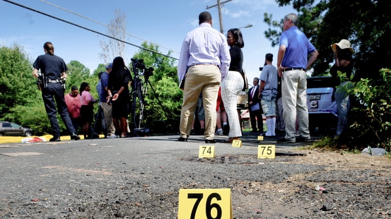 Bullet casings litter the ground behind a press conference on...