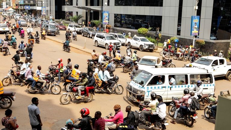 Drivers of motorcycle taxis, known locally as boda-bodas, ride with...