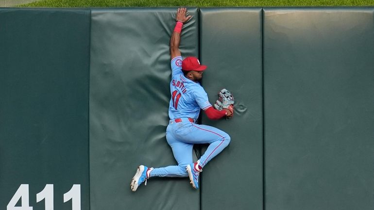 St. Louis Cardinals center fielder Victor Scott II crashes into...