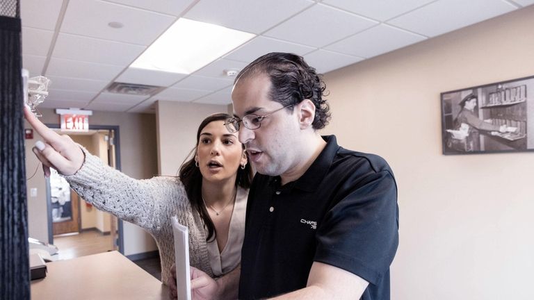 Nicholas Romano of Nesconset, right, gets training in mailroom operations with...