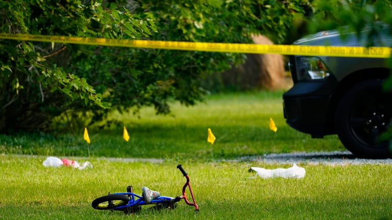 A child's bike, along with evidence markers, are shown in...