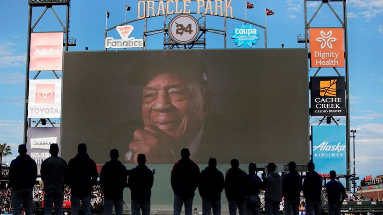The Cubs stand during a tribute to Willie Mays on...