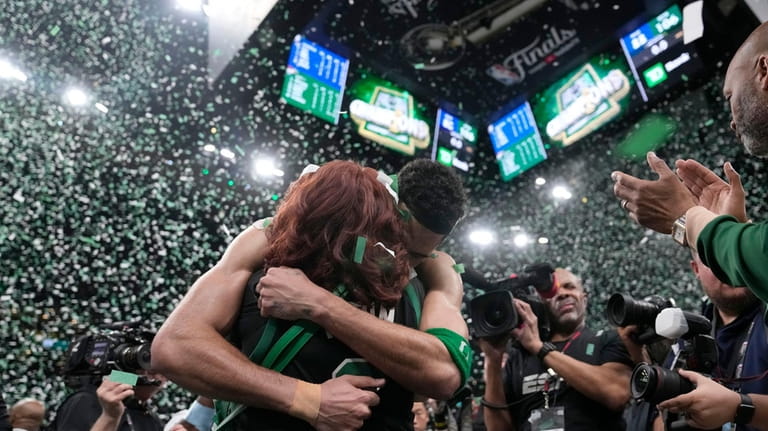 Boston Celtics forward Jayson Tatum, center right, embraces his mother...