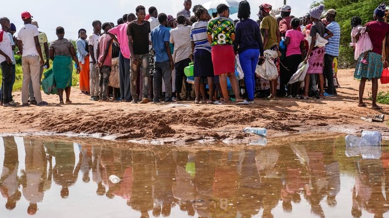 Residents gather for a planned distribution of food, after El...