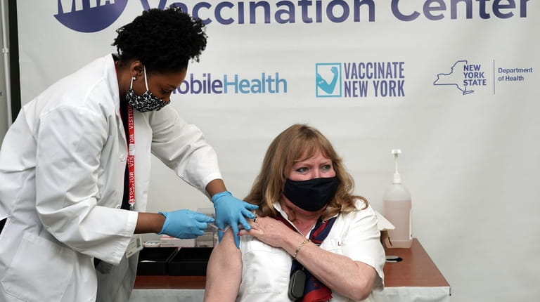 Ann Gilmour, of Ronkonkoma, gets a COVID-19 vaccine shot from Jodiane Ashpole,...
