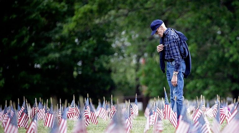 A man pays his respects after praying at Calverton National...