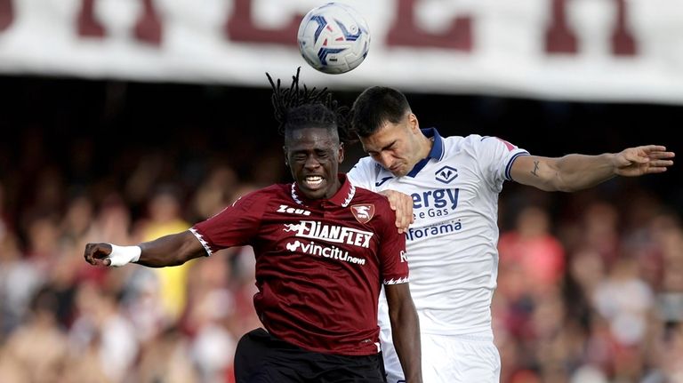 Salernitana's Loum Tchaouna, left, and Verona's Diego Coppola, right, challenge...