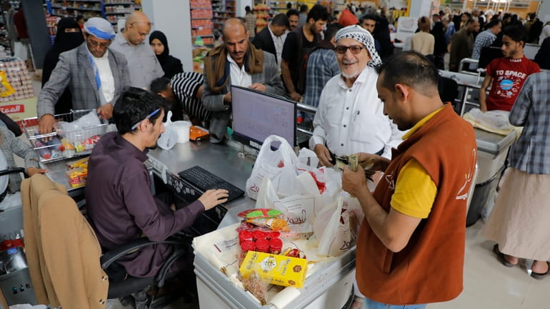 People shop in a supermarket in Sanaa, Yemen, before the...