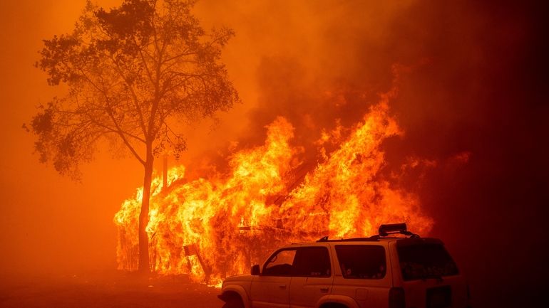 Flames consume a building as the Park Fire tears through...