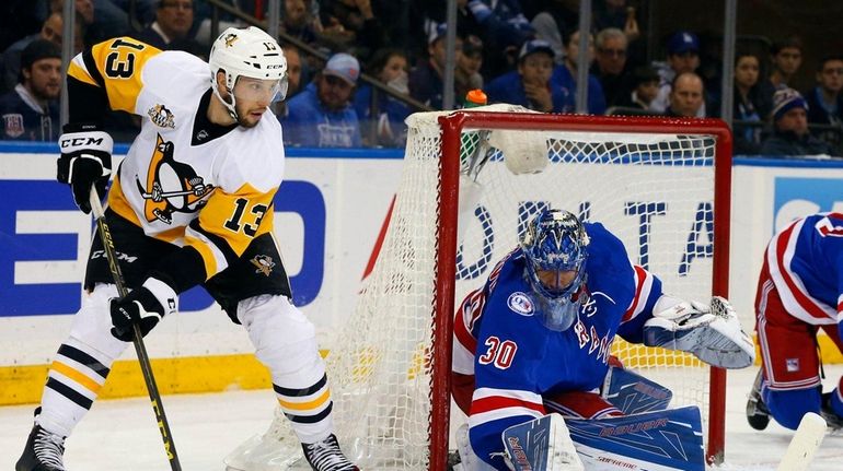 Henrik Lundqvist #30 of the New York Rangers defends the...