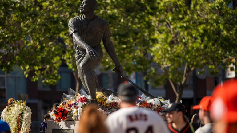 Fans walk by a tribute for the late Willie Mays...