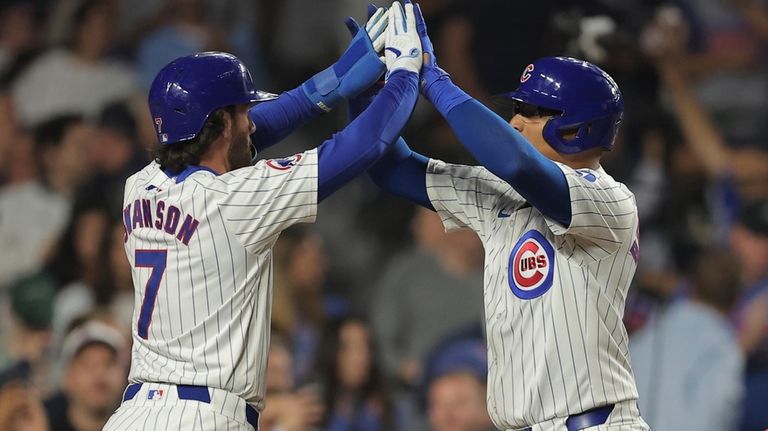 Chicago Cubs' Christian Bethancourt, right, celebrates with Dansby Swanson, left,...