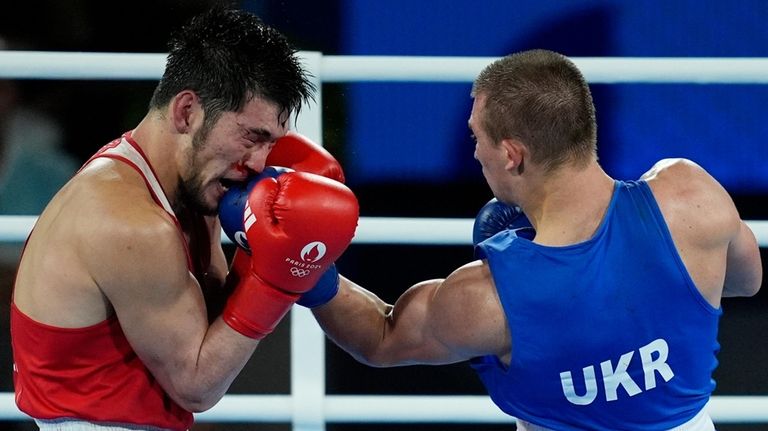 Kazakhstan's Nurbek Oralbay, left, fights Ukraine's Oleksandr Khyzhniak in their...