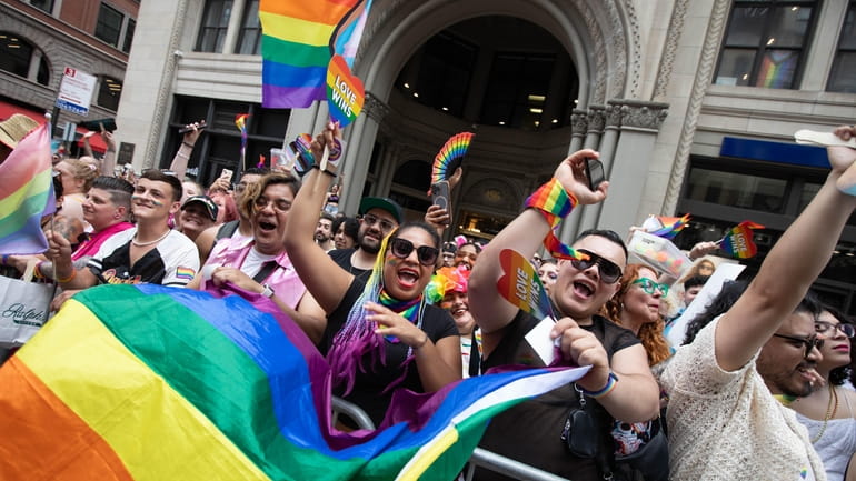 Spectators cheer along Fifth Avenue during the annual NYC Pride...