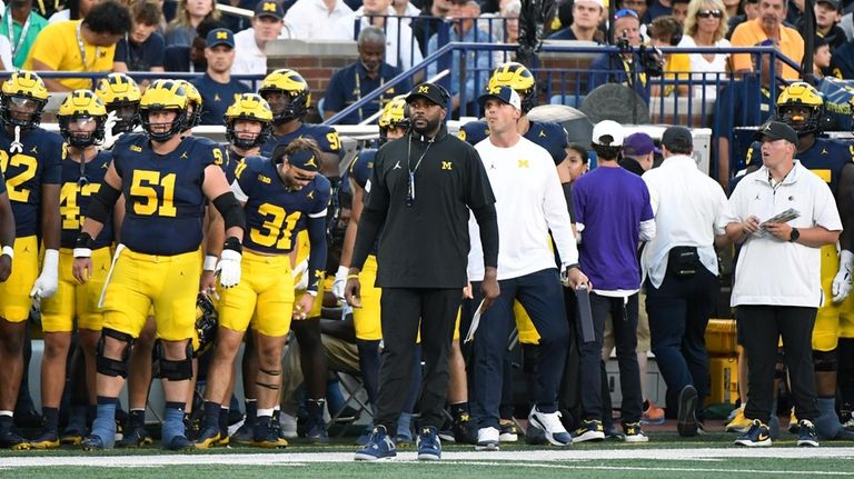 Michigan head coach Sherrone Moore, front center, watches his team...