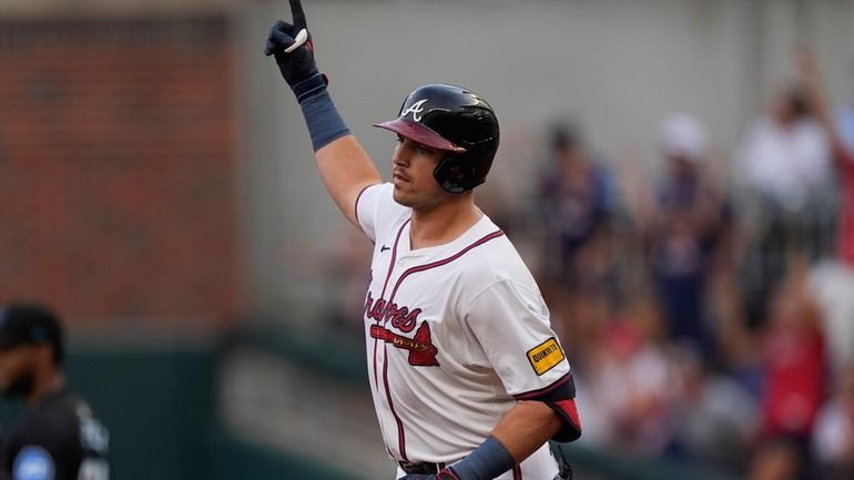 Atlanta Braves' Austin Riley gestures as he rounds the bases...