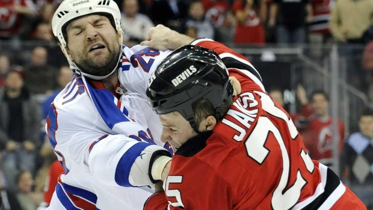 New Jersey Devils' Cam Janssen, right, fights with New York...