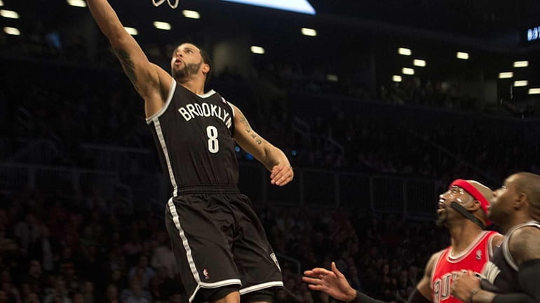 Nets' Deron Williams lays up the ball after getting past...