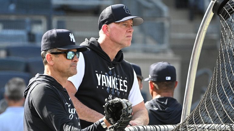 Yankees hitting coach Sean Casey and manager Aaron Boone observe...