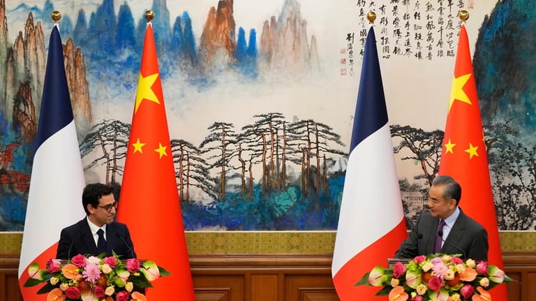 Chinese Foreign Minister Wang Yi, right, and French Foreign Minister...