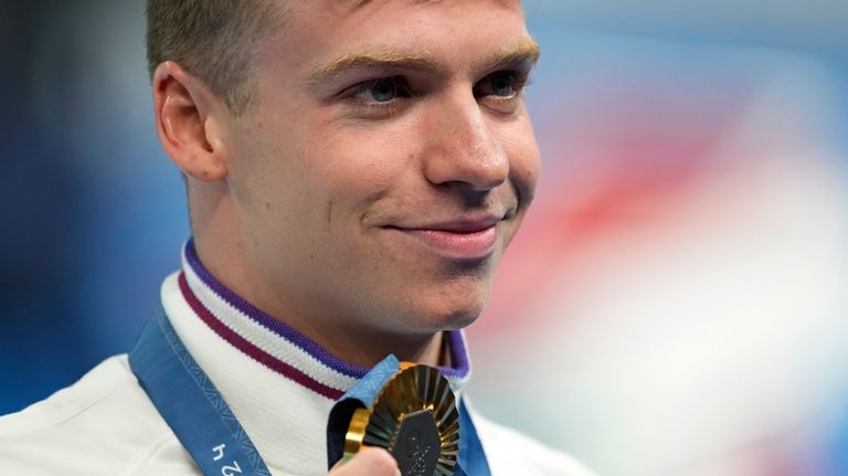 Leon Marchand of France, poses with his gold medal for...