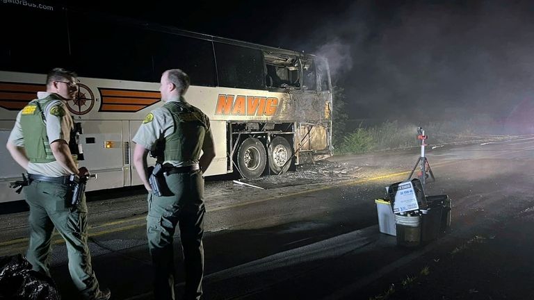 In this photo provided by J.D. Scholten, a bus carrying...