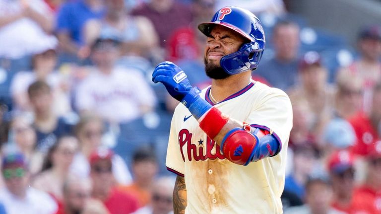 Philadelphia Phillies' Edmundo Sosa reacts after being hit by a...