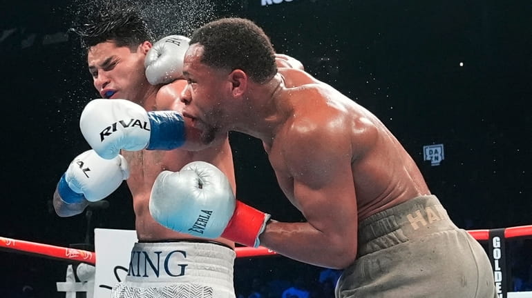 Devin Haney, right, punches Ryan Garcia during the 12th round...
