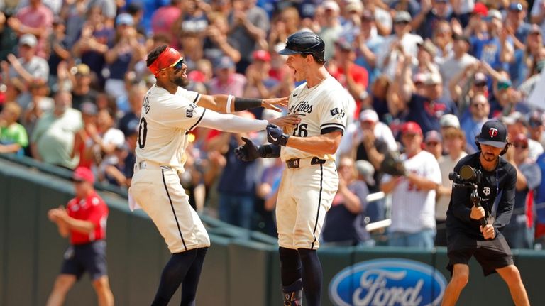 Minnesota Twins' Willi Castro, left, joins Max Kepler in celebrating...