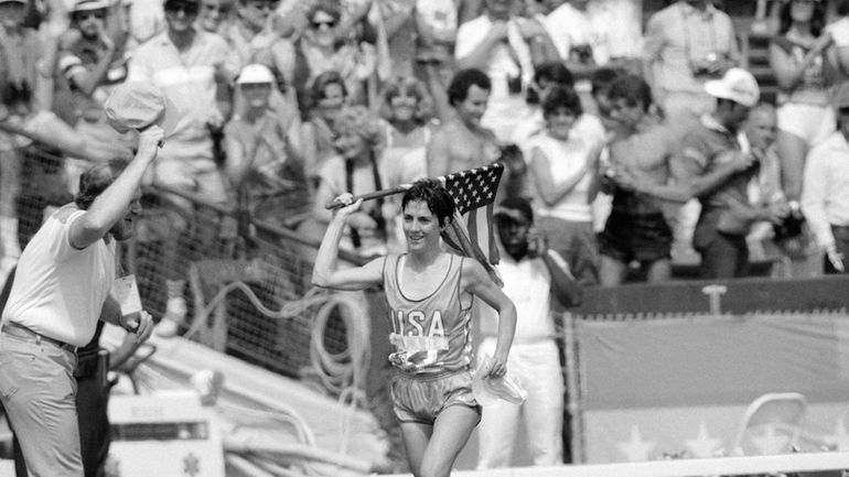 Twenty-seven-year-old Joan Benoit of Freeport, Maine, waves the American flag...