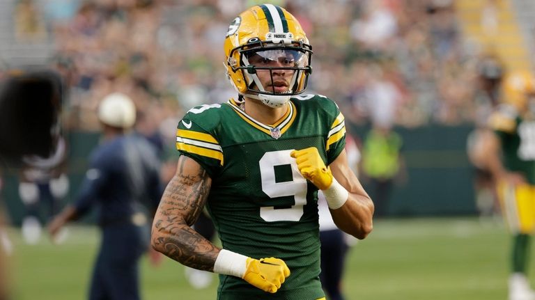 Packers wide receiver Christian Watson warms up before an NFL preseason...