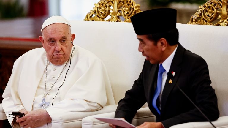 Pope Francis, left, and Indonesian President Joko Widodo attend a...