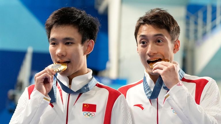 China's Lian Junjie and Yang Hao celebrate on the podium...