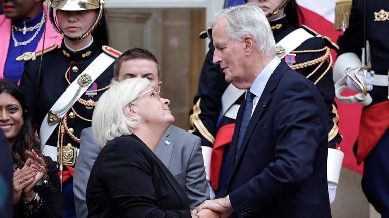 New French prime minister Michel Barnier, right, is greeted by...