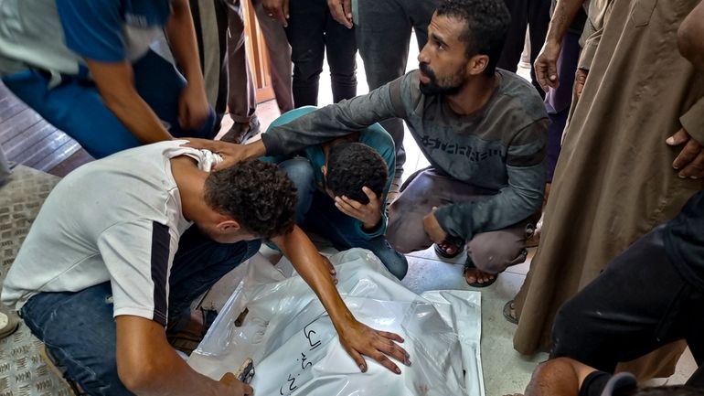 Palestinians mourn a relative killed in the Israeli bombardment of...