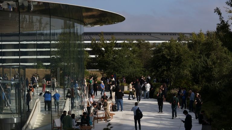 Attendees wait inside and outside the Steve Jobs Theater before...