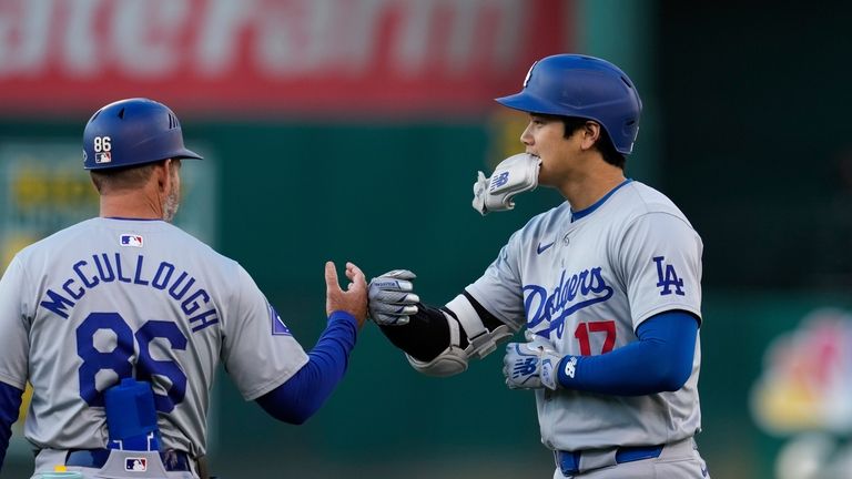 Los Angeles Dodgers' Shohei Ohtani, right, celebrates with first base...