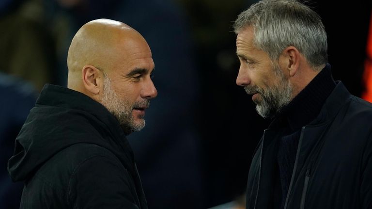 Manchester City's head coach Pep Guardiola, left, greets Leipzig's head...