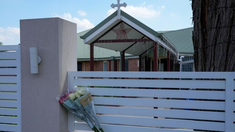 Flores sit on a fence outside the Christ the Good...