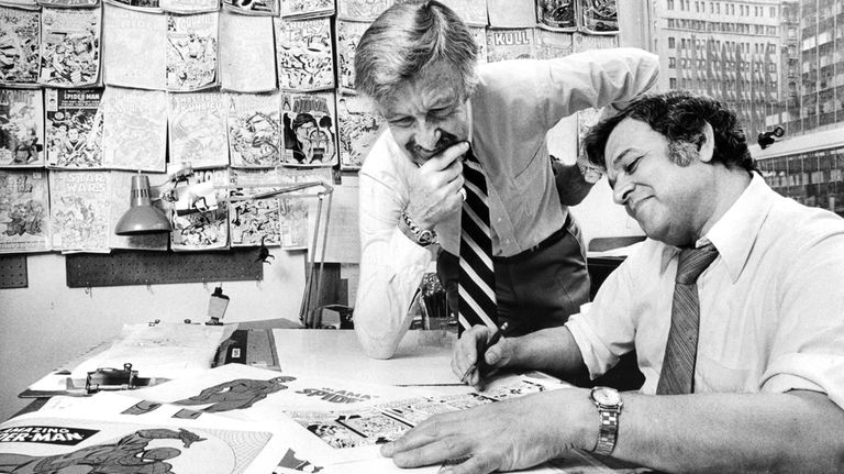 Comic book creator Stan Lee, left, and John Romita go over...