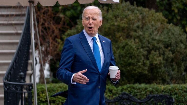 President Joe Biden walks out of the White House in...