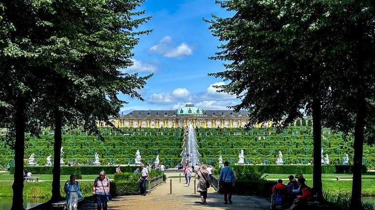 People walk in the park of the Sanssouci Palace in...