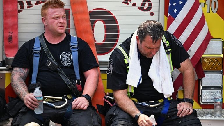 Dix Hills Firefighters Ryan Leavy, left, and Adam Tomko take a...