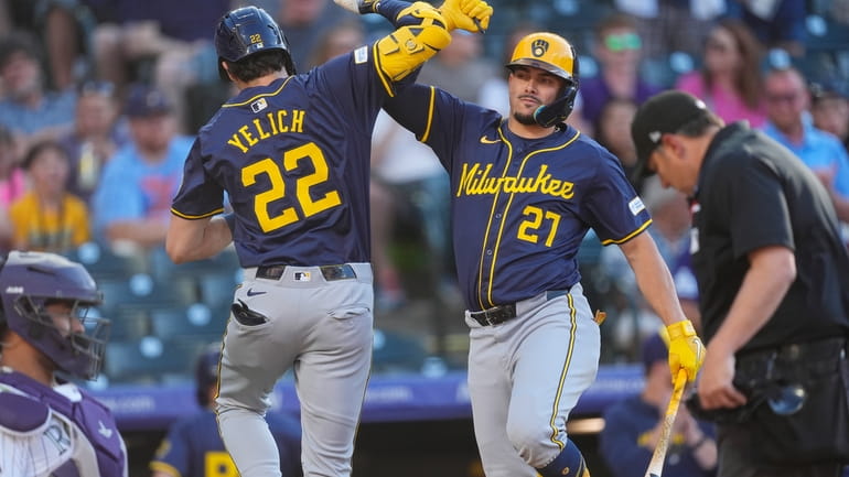 Milwaukee Brewers' Willy Adames, right, congratulates Christian Yelich after his...