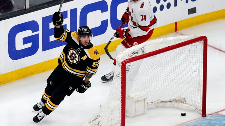 Boston Bruins' Brad Marchand (63) celebrates his goal, next to...