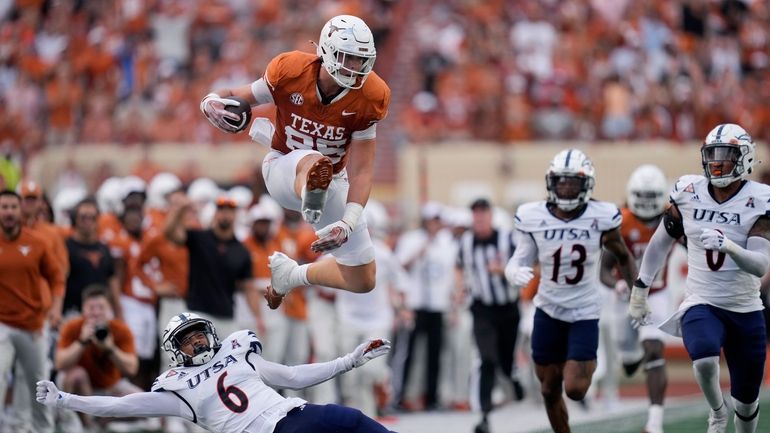 Texas tight end Gunnar Helm (85) lea[ps over UTSA safety...