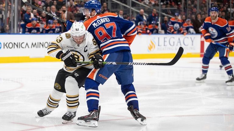 Boston Bruins' Brad Marchand (63) and Edmonton Oilers' Connor McDavid...