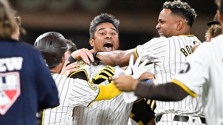 San Diego Padres' Donovan Solano, center, celebrates after hitting a...