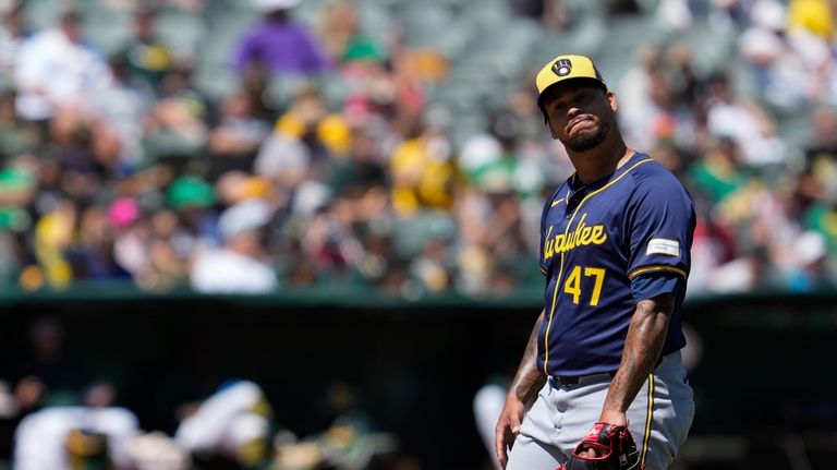 Milwaukee Brewers pitcher Frankie Montas reacts after walking Oakland Athletics'...