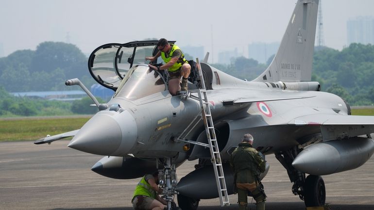 Crew members inspect a France's Rafale fighter jets during visiting...